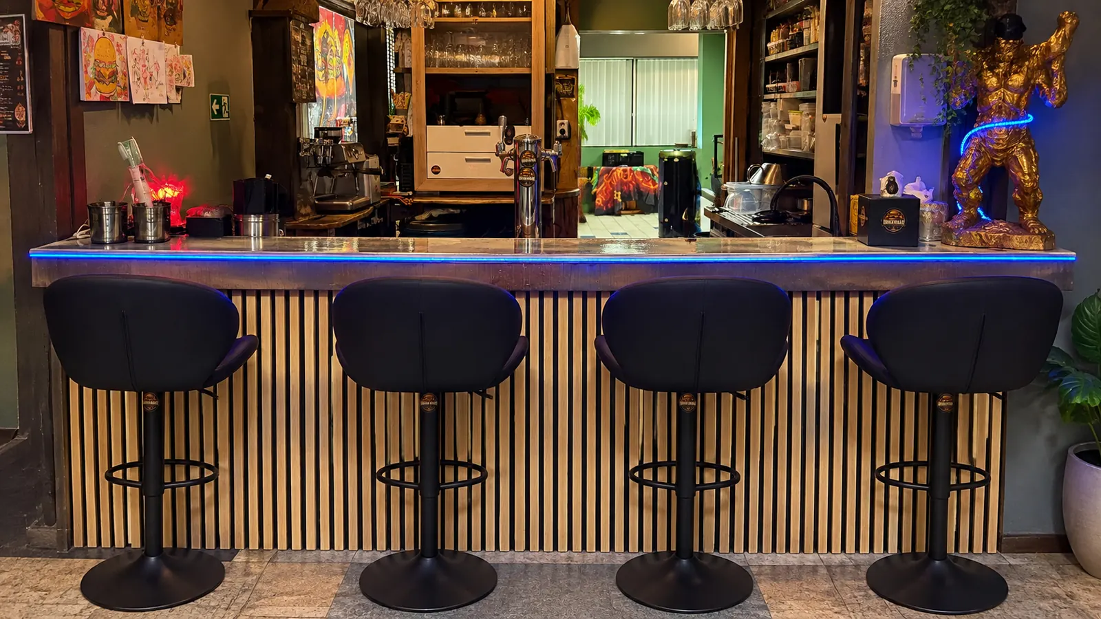 The bar counter with four bar stools, plants and blue LED light