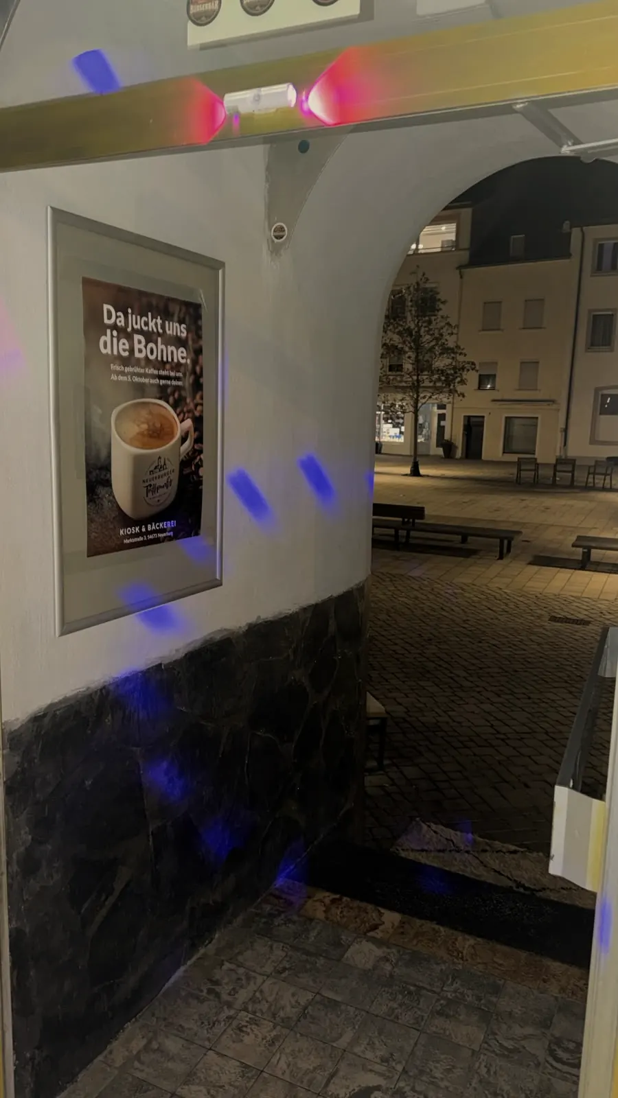 Der Eingang am Abend, davor der Marktplatz